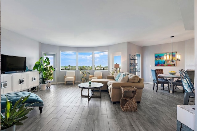 living room featuring dark wood-style floors, baseboards, and a chandelier