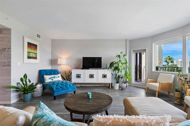 living area featuring wood finished floors, visible vents, and baseboards