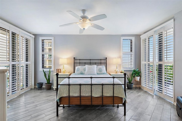 bedroom with baseboards, wood finish floors, and a ceiling fan