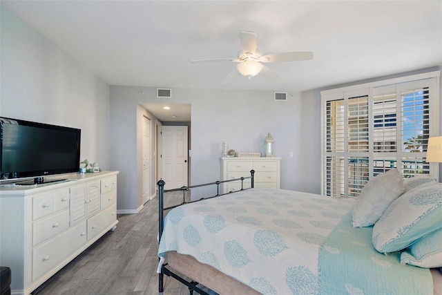 bedroom featuring a ceiling fan, wood finished floors, visible vents, and baseboards