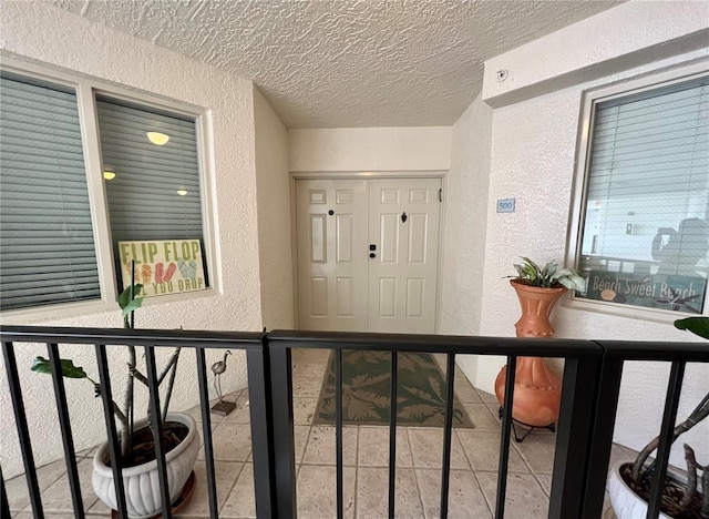 doorway to property featuring stucco siding and a balcony