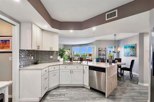 kitchen featuring visible vents, dishwasher, decorative backsplash, a peninsula, and a sink