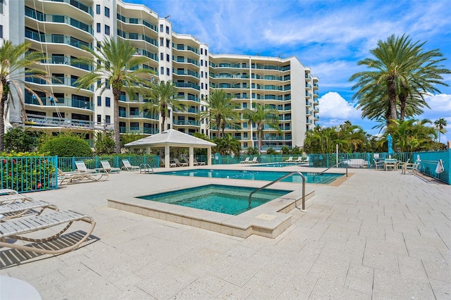 view of pool featuring a gazebo, a community hot tub, fence, and a patio