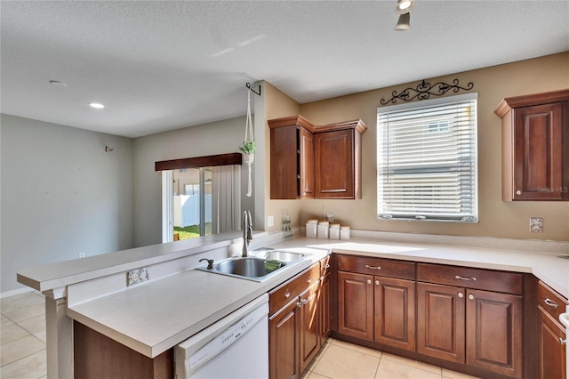 kitchen featuring sink, light tile patterned floors, dishwasher, and kitchen peninsula