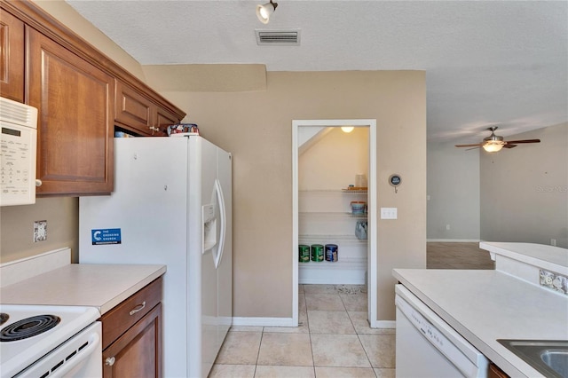 kitchen featuring white appliances, ceiling fan, a textured ceiling, and light tile patterned floors