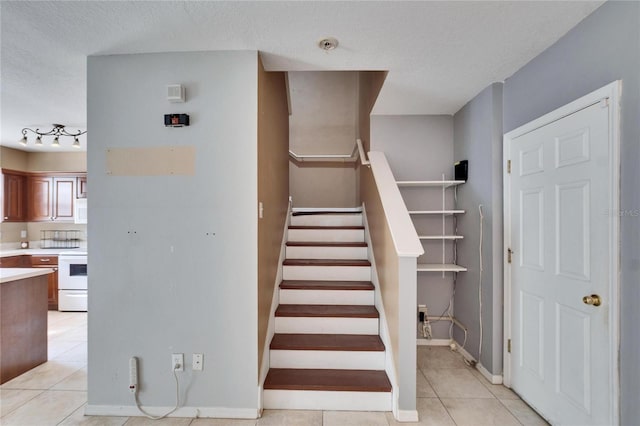 staircase featuring tile patterned flooring and a textured ceiling