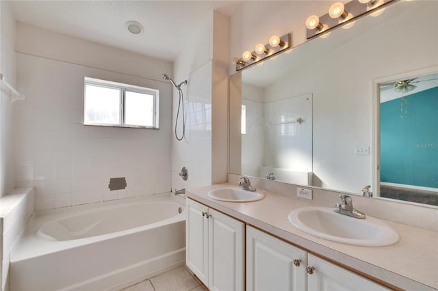 bathroom featuring tile patterned flooring, vanity, and tiled shower / bath