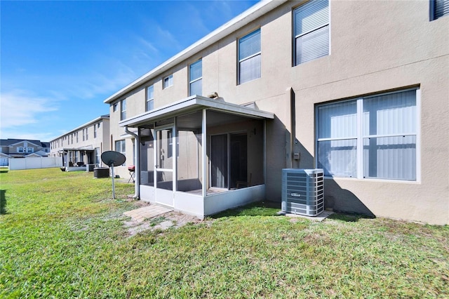 back of property featuring central AC, a sunroom, and a lawn