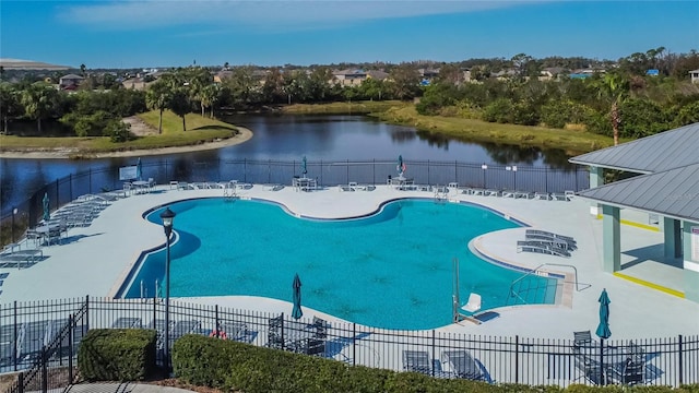 view of swimming pool with a patio area and a water view