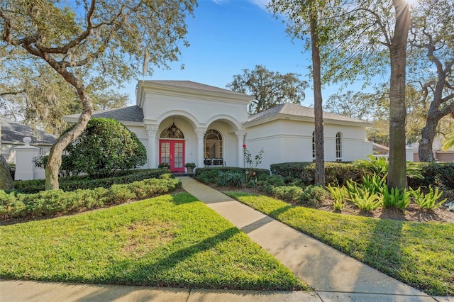 mediterranean / spanish home featuring french doors and a front lawn