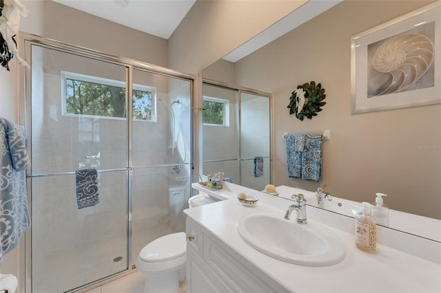 bathroom featuring toilet, a shower with door, and vanity