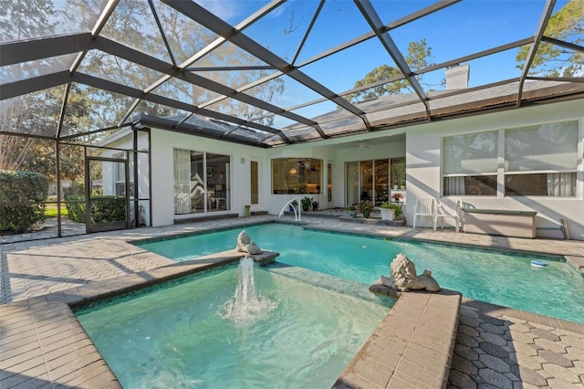 view of pool with ceiling fan, a patio, glass enclosure, and an in ground hot tub