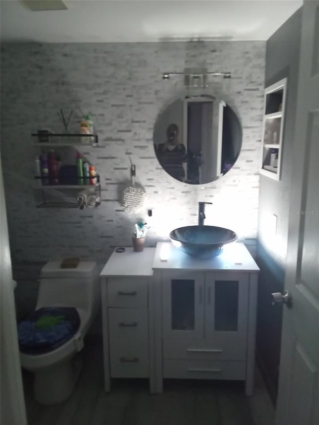 bathroom with vanity, backsplash, built in shelves, and toilet