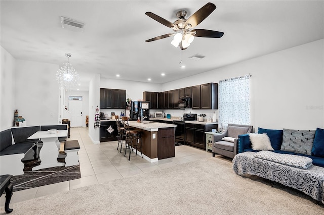 living room featuring light tile patterned flooring, ceiling fan, and sink