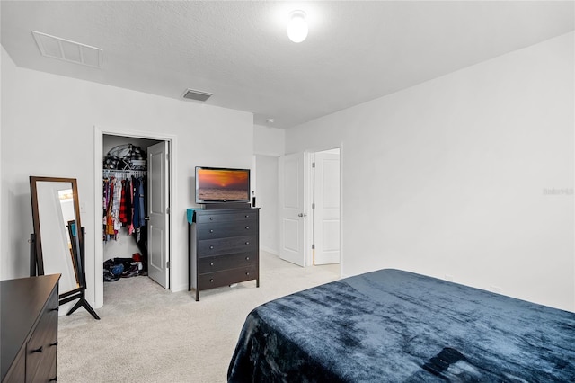 carpeted bedroom with a textured ceiling and a closet