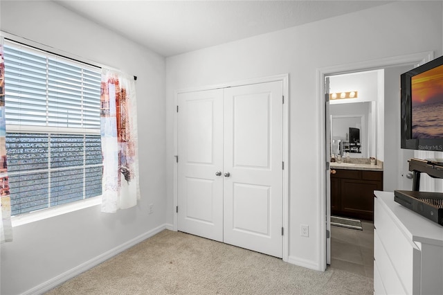 carpeted bedroom featuring connected bathroom and a closet