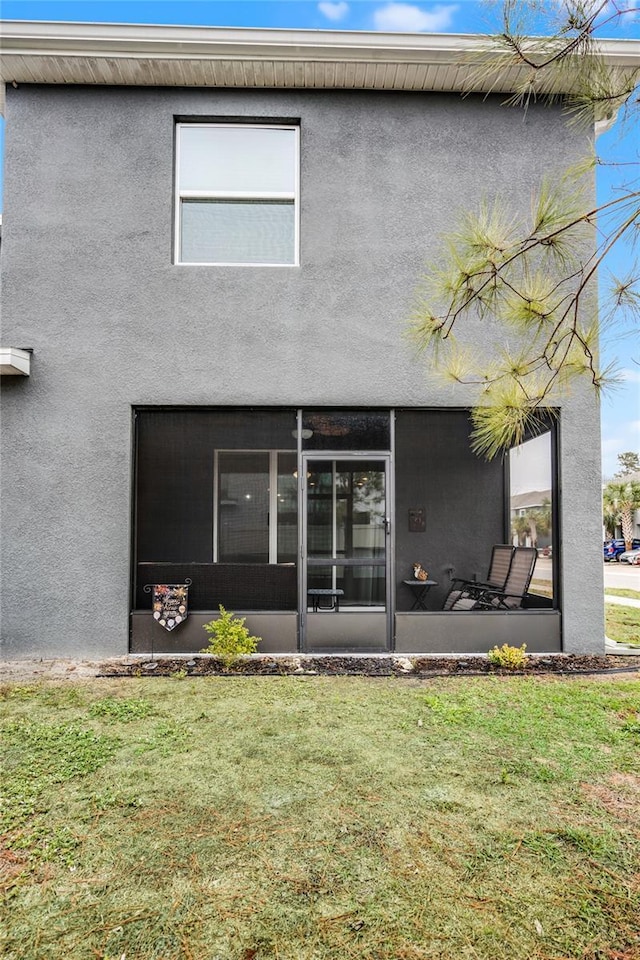 back of house featuring a sunroom and a yard