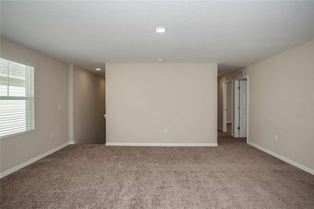 unfurnished room featuring light colored carpet and a textured ceiling