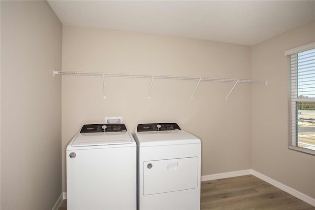 clothes washing area with hardwood / wood-style flooring and washing machine and clothes dryer