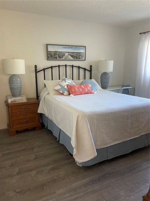 bedroom featuring a textured ceiling and dark hardwood / wood-style floors