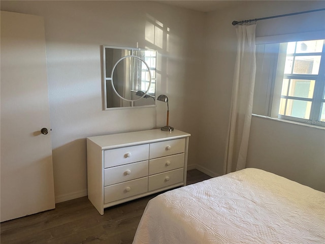 bedroom with dark hardwood / wood-style floors