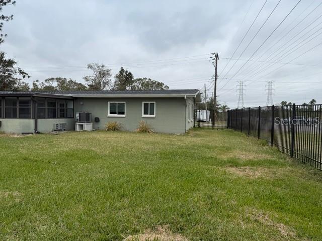 view of yard featuring a sunroom and central AC unit