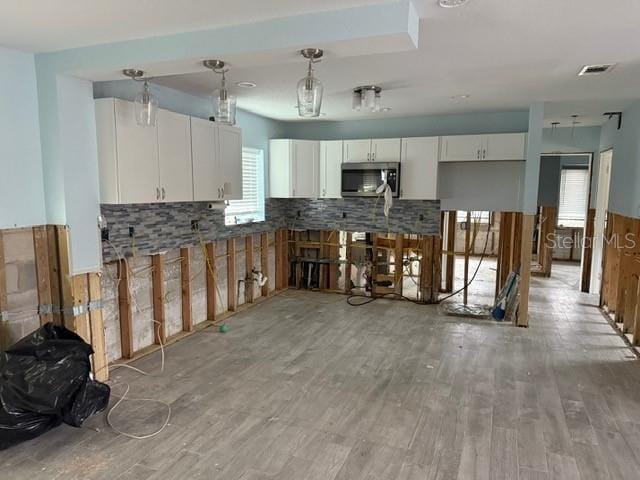 kitchen featuring white cabinetry, decorative light fixtures, light hardwood / wood-style flooring, and decorative backsplash