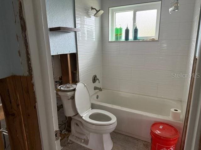 bathroom with toilet and tiled shower / bath combo