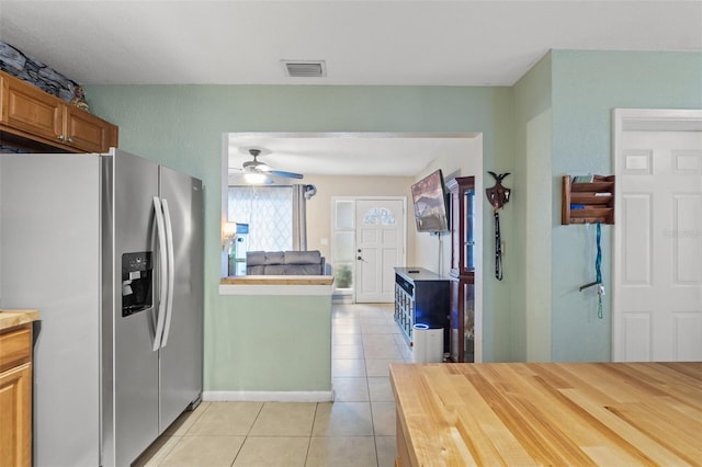 kitchen with light tile patterned flooring, ceiling fan, and stainless steel fridge