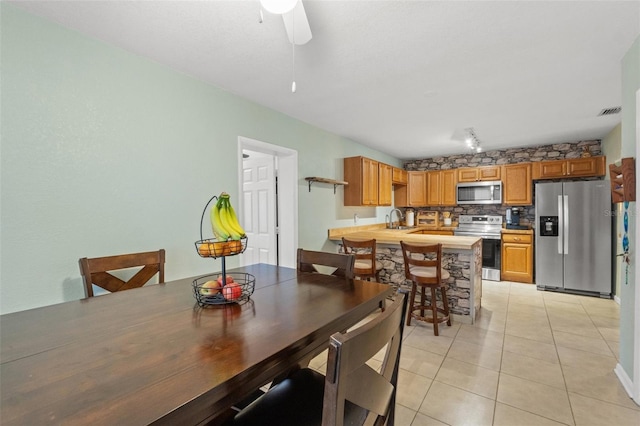 dining area with sink, light tile patterned floors, track lighting, and ceiling fan