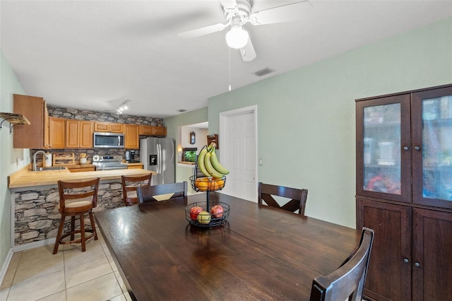 tiled dining room with sink and ceiling fan