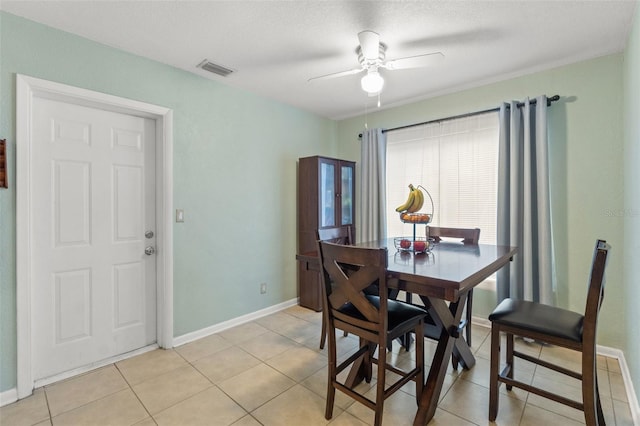 dining area with light tile patterned floors, a textured ceiling, and ceiling fan