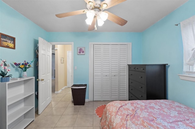 bedroom featuring ceiling fan, a closet, and light tile patterned floors