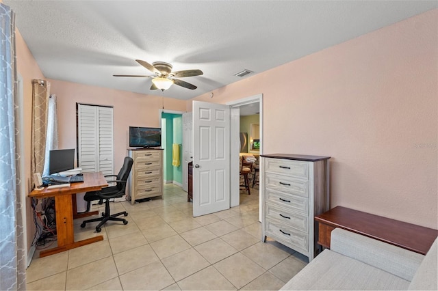 tiled home office featuring a textured ceiling and ceiling fan