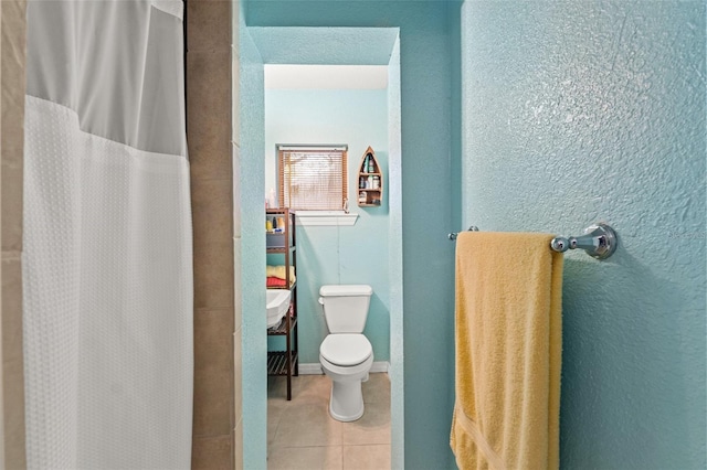 bathroom featuring a shower with curtain, tile patterned floors, and toilet