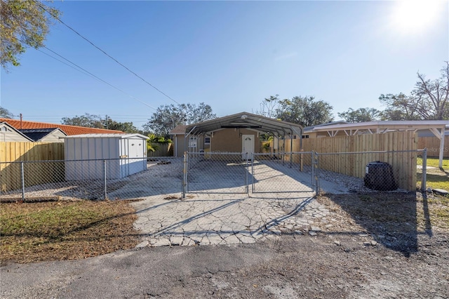 rear view of house featuring a carport and a storage shed