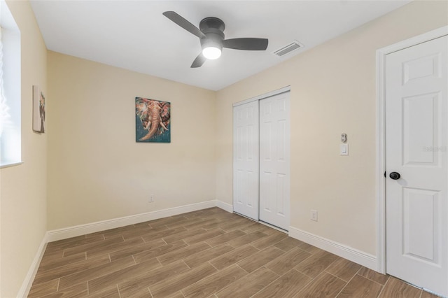 unfurnished bedroom featuring ceiling fan and a closet