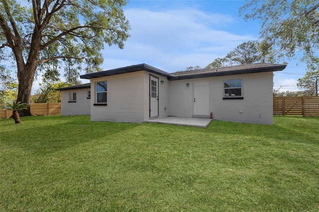 rear view of house with a lawn and a patio area