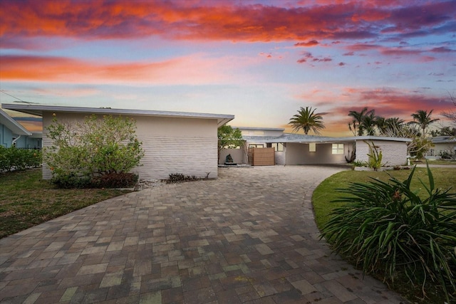 property exterior at dusk featuring a yard