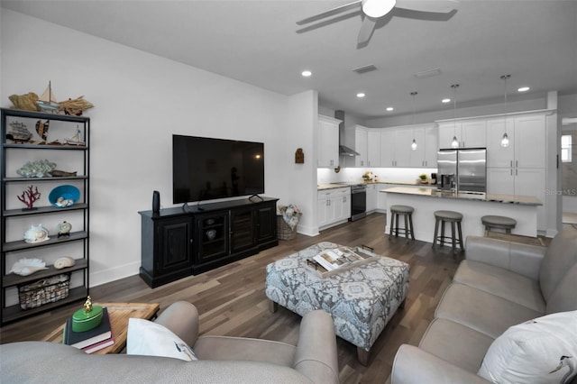 living room featuring ceiling fan and dark hardwood / wood-style flooring