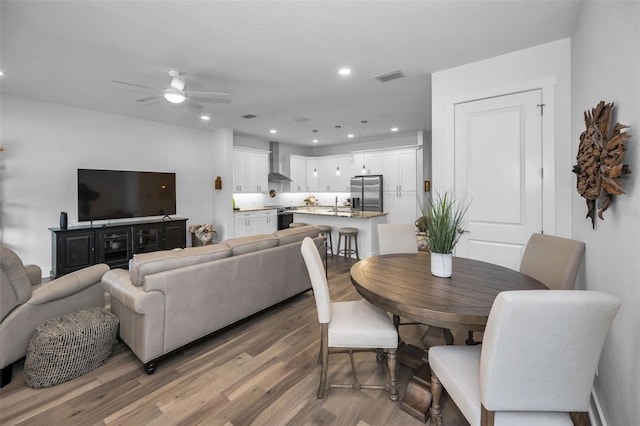 dining space with light wood-type flooring and ceiling fan