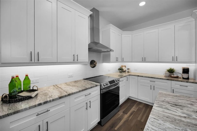 kitchen featuring dark wood-type flooring, wall chimney range hood, white cabinets, and stainless steel electric range oven