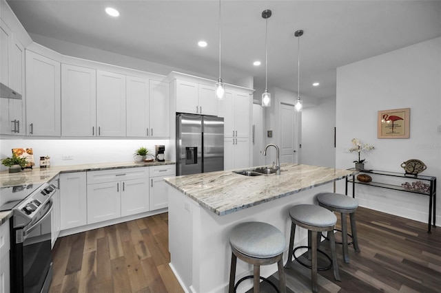 kitchen with sink, hanging light fixtures, an island with sink, stainless steel fridge with ice dispenser, and white cabinets