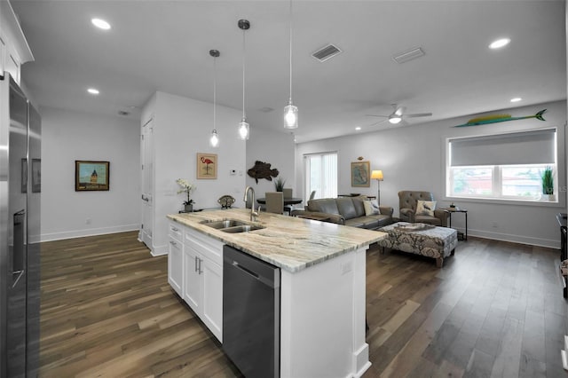 kitchen featuring white cabinetry, a center island with sink, stainless steel appliances, light stone counters, and sink