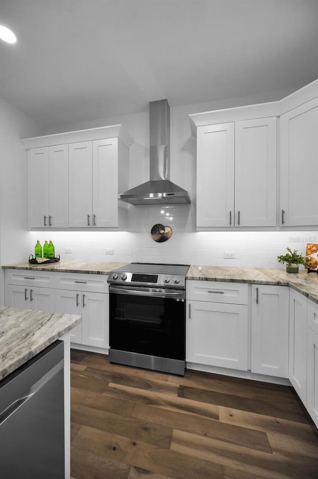 kitchen featuring wall chimney range hood, white cabinets, and stainless steel appliances