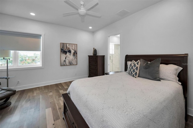 bedroom featuring ceiling fan, ensuite bath, and dark hardwood / wood-style floors