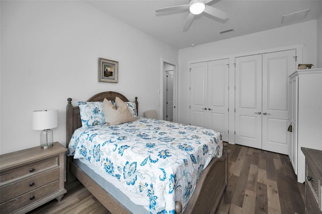 bedroom with ceiling fan, dark wood-type flooring, and two closets