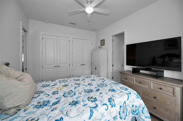 bedroom with ceiling fan and two closets