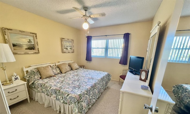 carpeted bedroom with a textured ceiling and ceiling fan