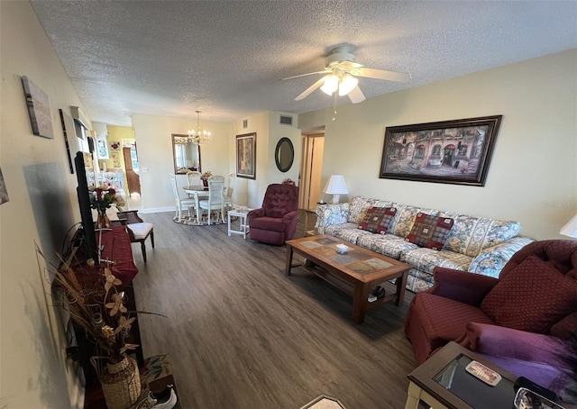 living room featuring ceiling fan with notable chandelier, hardwood / wood-style floors, and a textured ceiling